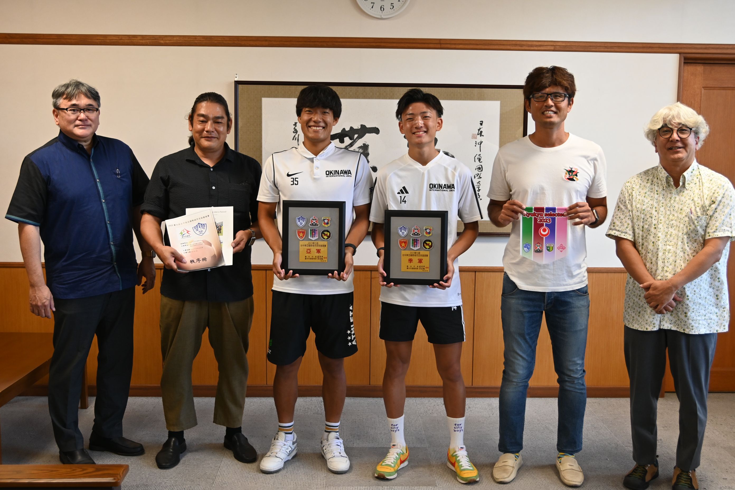 写真左から副学長安里先生、サッカー部顧問ともち先生、サッカー部の壽さん、佐々木さん、副顧問の島袋先生、学生部長の浦本先生