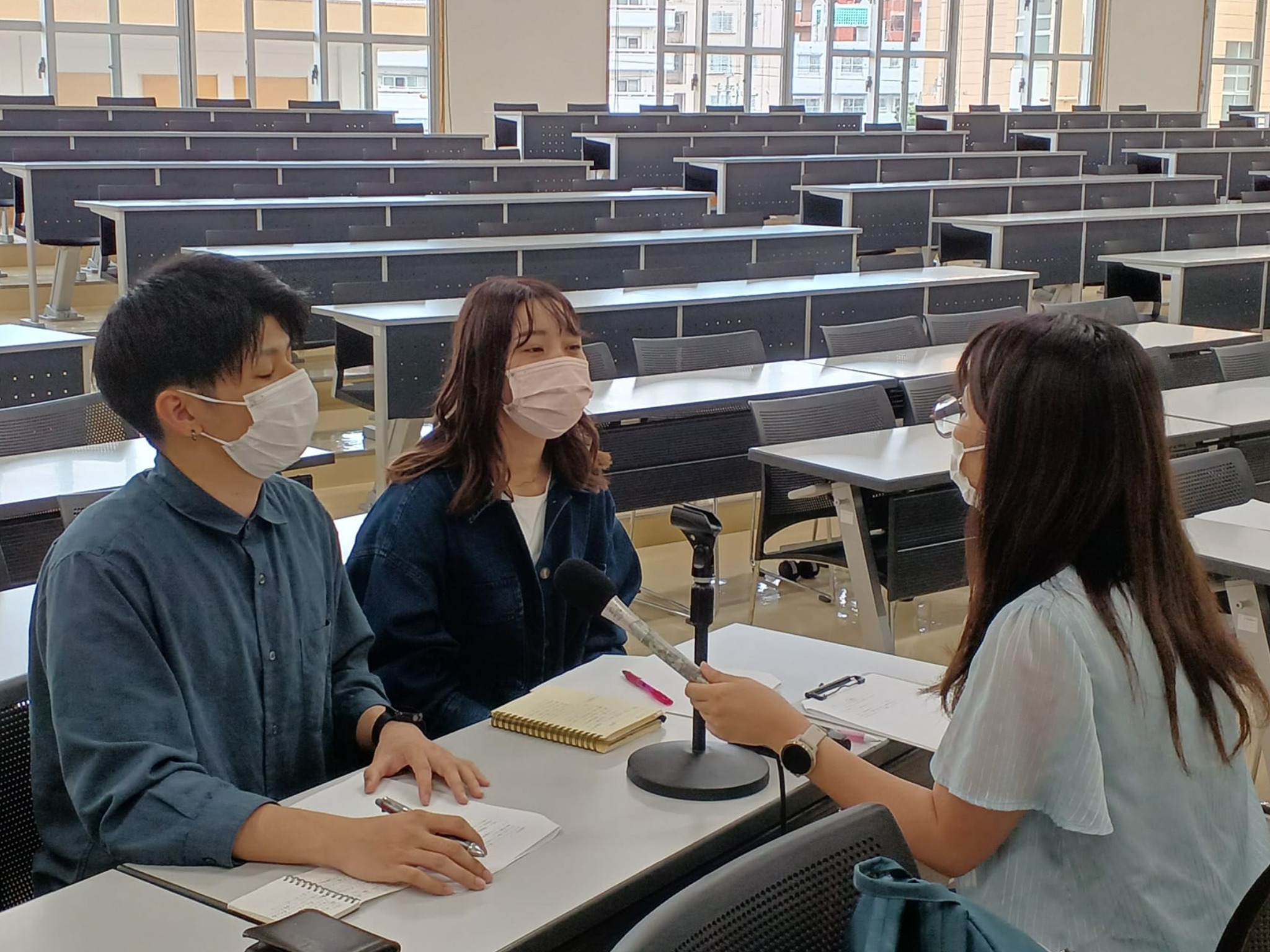 取材を受けるスマイライフ役員の名嘉眞くん写真左長嶺さん写真中央